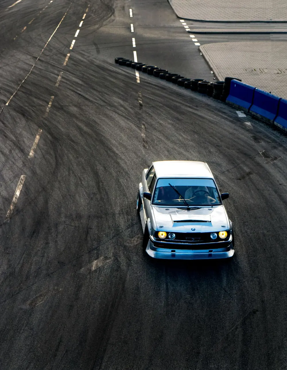 A drift car sliding through a corner on an asphalt circuit